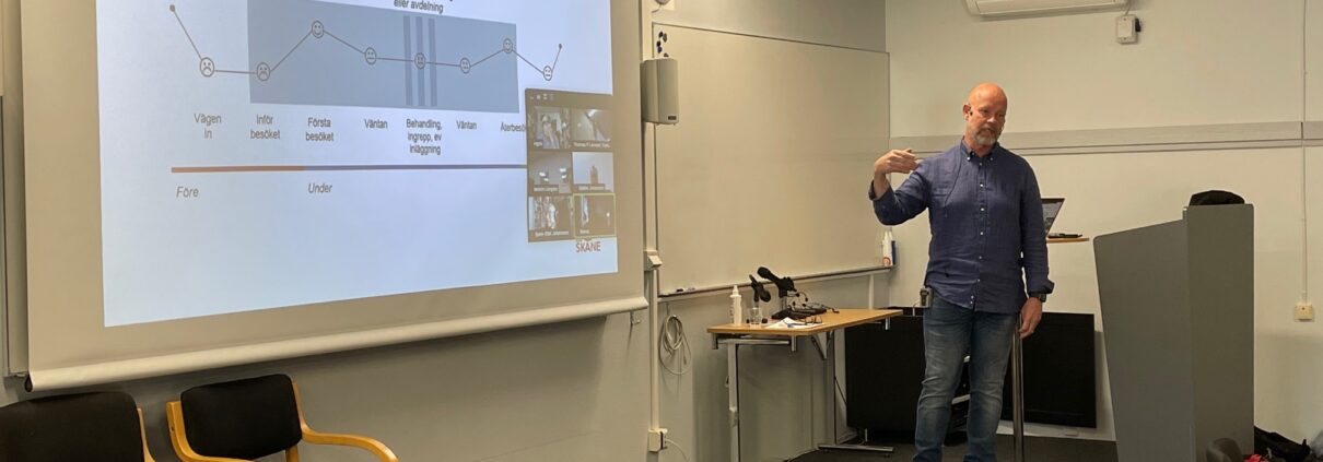 Bilden visar Greger Linander presentera en powerpoint.