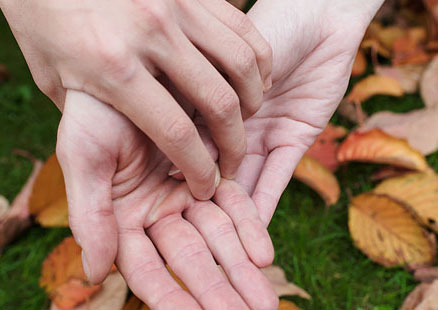 Flera händer som ligger i varandra - en symbol för samverkan.