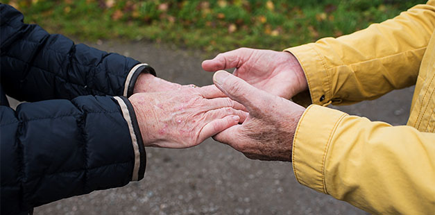 Två personer som lagt händerna i varandras händer - en symbol för samverkan.