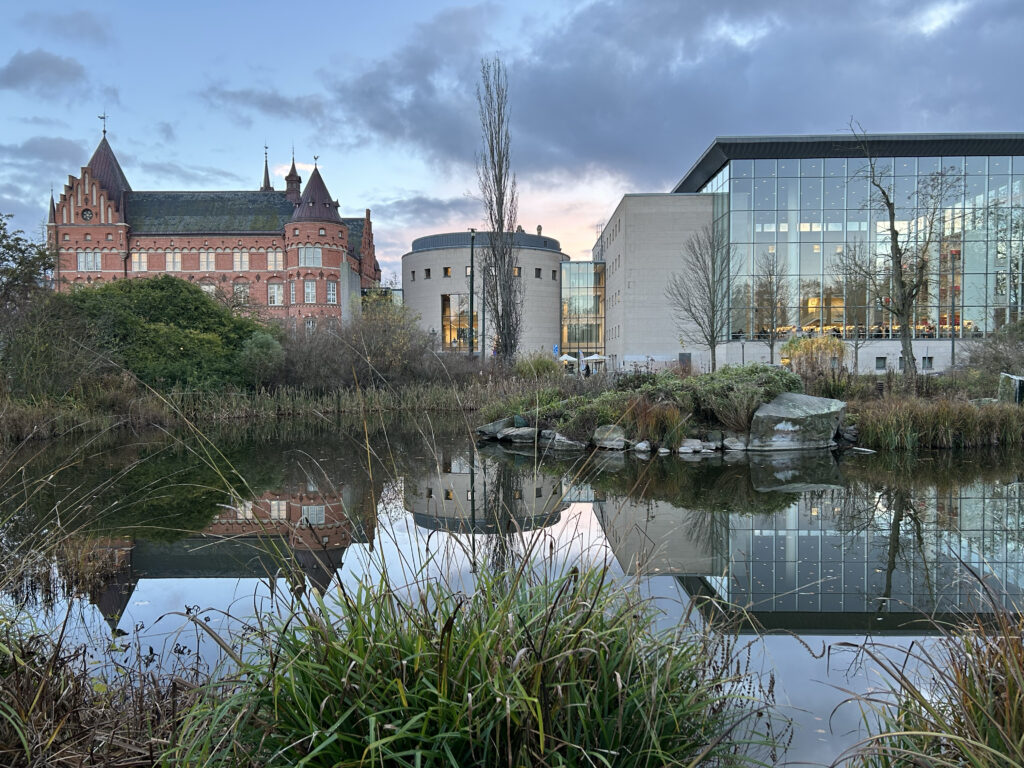 Malmö Stadsbiblioteks byggnad speglar sig i en damm.