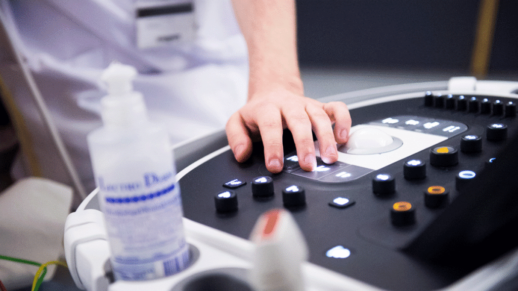 Vårdpersonals hand på medicinsk utrustning.